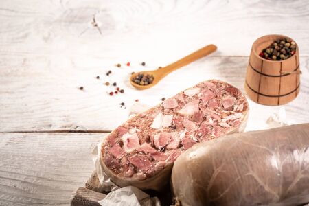 chunk of meat product saltison served with aromatic spices. Pork saltison on a wooden board. Delicious pork snack. menu recipe place for text.の写真素材