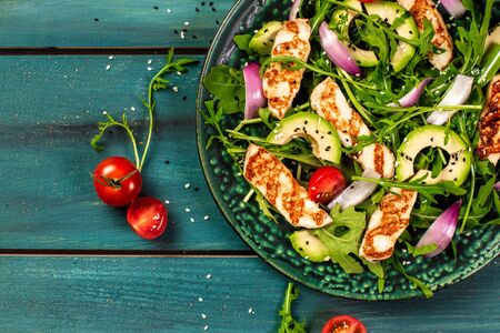 The concept of oriental cuisine. National Cyprus Salad with grilled halumi cheese, tomatoes, avocado, arugula. banner menu recipe place for text. Flat lay.の写真素材