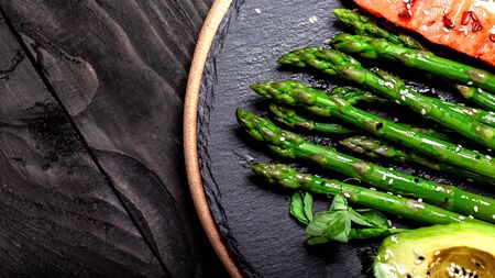 Ketogenic diet breakfast. Baked salmon garnished with asparagus and avocado. Top view. Food recipe background. Close up.の写真素材
