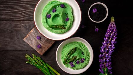 Creamy asparagus, spirulina and potatoes puree on a wooden table. Healthy food, ketogenic diet, diet lunch concept. Top view, overhead, banner.の写真素材
