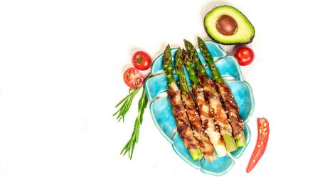 Balanced lunch. Plate with bacon wrapped asparagus on light background. space for text. top view.の写真素材