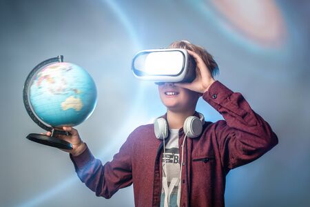 Young boy wearing and learning with a VR goggles. against boy using a virtual reality device.
