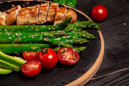 plate of freshly grilled roasted chicken meat and grilled asparagus Food recipe background. Close up.のeditorial素材