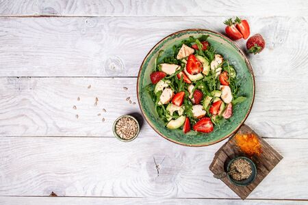 Fresh strawberry salad with arugula, chicken, avocado and strawberries. Plate with a keto diet food. Top view.の写真素材