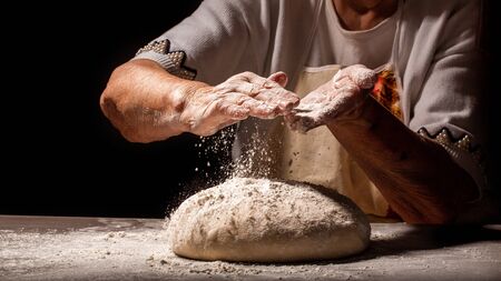 White flour flying into air as pastry, slams ball dough. Food concept. space for text.の写真素材