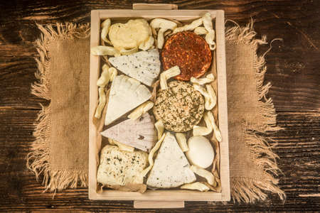 Cheese plate with different types of cheese with honey and nuts. Rustic background.
