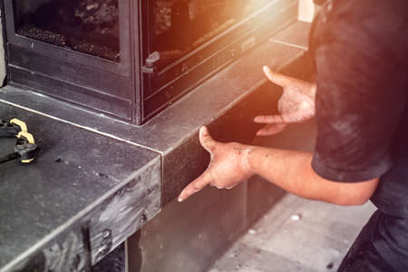 Tillers and fireplace. epairman repairs and installs a fireplace in the apartment.の写真素材