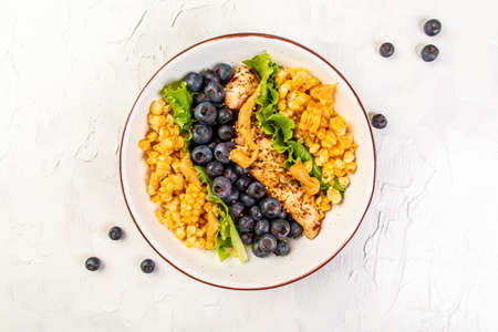 Ketogenic diet breakfast. Chicken salad with corn, lemon, mustard blueberries. Keto paleo lunch. Top view.の写真素材