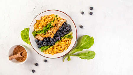 Healthy organic salad with berries and salad greens, Delicious breakfast or snack on a light background, top view.の写真素材