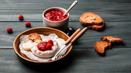 Baked or fried Camembert or brie cheese with raspberries and raspberry jam. Gourmet Breakfast. Italian, French cheese.の写真素材