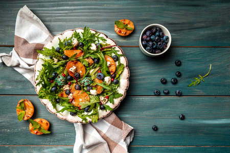 Vibrant grilled peach salad with blueberries and creamy goat cheese, Healthy vegan salad, place for...