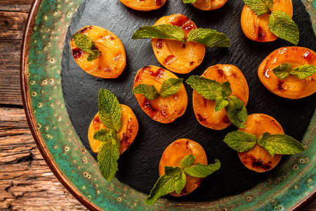 Grilled peaches, apricots, nectarines on the rustic background. Food recipe background. close up.の写真素材