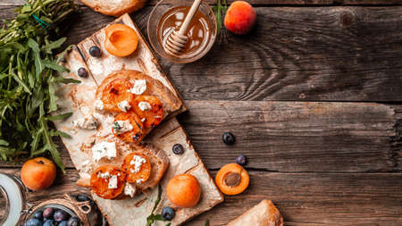 Summer snack sandwiches with grilled peaches, dor blue cheese, wooden background, banner, catering...