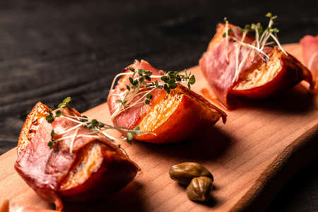 appetizer Grilled peach with prosciutto, capers, microgreen, Food recipe background.の写真素材