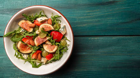 Diet menu. Healthy salad of fresh figs, strawberries, grapes, blue cheese dorblu. Long banner format, top view,の写真素材