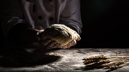 Beautiful and strong men's hands knead the dough from which they will then make bread, pasta or...