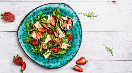 salad with arugula, strawberries and cheese brie, camembert. Healthy food diet food concept. recipe background.の写真素材