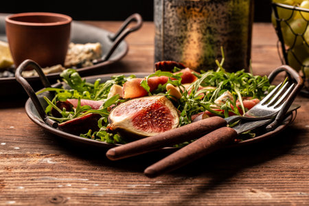 Delicious gourmet cheese, assortment of soft cheeses served with sliced sweet fresh figs and grapes on a rustic wooden background, catering, banner, menu, recipe, place for text.の写真素材