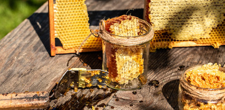 Natural honey comb and glass jar on wooden table. Honey background. bee products by organic natural ingredients concept, closeup.の写真素材