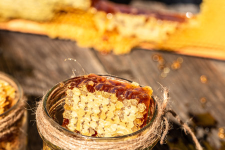 Natural honey comb and glass jar on wooden table. Honey background. bee products by organic natural...