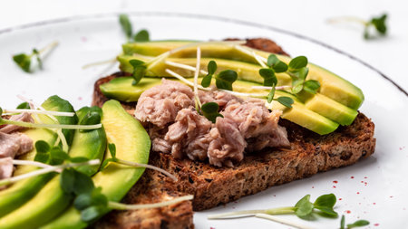 Toast with canned tuna, avocado, microgreen. Delicious breakfast or snack. Top viewの写真素材