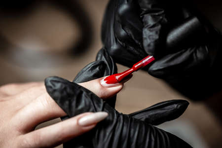 Manicurist Hand Painting Clients Nails. Manicure care procedure, Close-up photo Of Beautician Hand Filing Nails Of Woman In Salonの写真素材