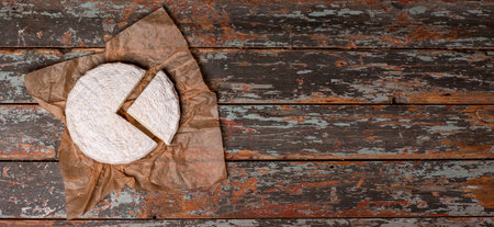 Delicious brie cheese isolated. Brie type of cheese. Membert. Fresh Brie cheese and a slice. Italian, French cheese. top view. Long banner format.の写真素材