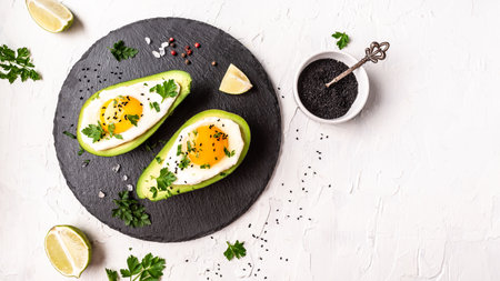 Avocado stuffed with eggs. Delicious and healthy food, Delicious breakfast or snack on a light background, top view.の写真素材