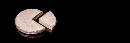 Delicious brie cheese isolated on black reflective background. Brie type of cheese. Camembert. Fresh Brie cheese and a slice. Italian, French cheeseの写真素材