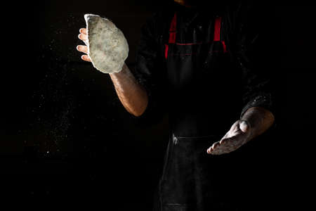 hands of baker with flour. Kneading the Dough. Isolated on dark background. Restaurant menu, cookbook recipeの写真素材