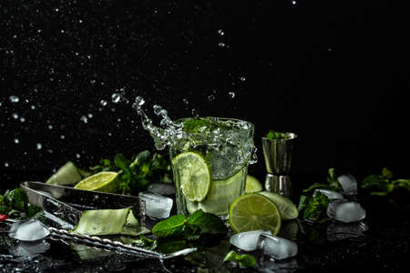 Summer homemade lemonade made from lime, lemon, cucumber with ice in glass, drink with liquid...