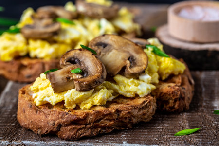 Scrambled egg with mushrooms and cottage cheese on toast. Food recipe background. close up.