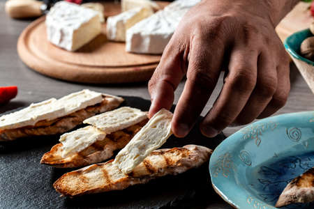 Bruschetta sandwiches with strawberries, cheese, camembert, brie, nuts and honey cooking by chef...