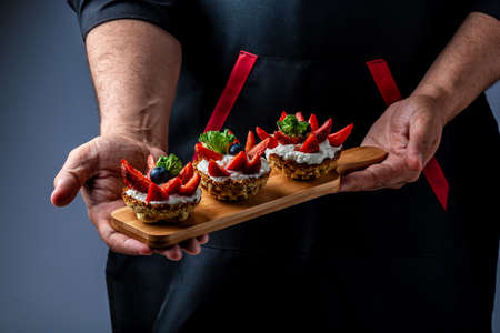 Close up master chef hands making a delicious strawberry tart with cream berries, cooking by chef hand. banner menu recipe place for textの写真素材