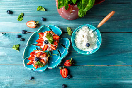 Strawberry shortcake tarts, perfect party individual fresh fruit dessert on tidewater green background, banner, catering menu recipe place for text, top view. Long banner format, top viewの写真素材