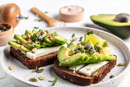 healthy toasts with avocado cheese and whole wheat rye bread on a plate. Delicious snacks and avocado sandwiches. Vegetarian food. Vegan menu. Food recipe background.の写真素材