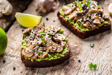 bread with avocado and mushrooms. Vegetarian food. Vegan menu. Food recipe background. close up.の写真素材