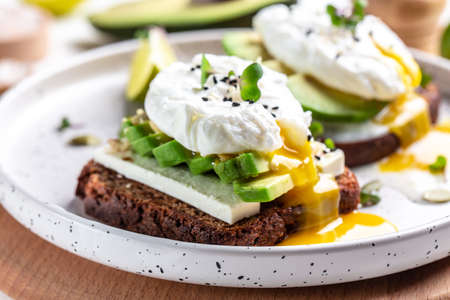 Sandwich with avocado and poached egg. Healthy nutritious paleo keto breakfast concept.