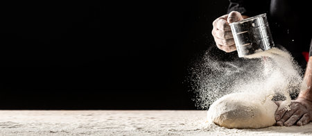 professional Chef hands prepares dough from flour to cook Italian pasta, pizza on a dark background....