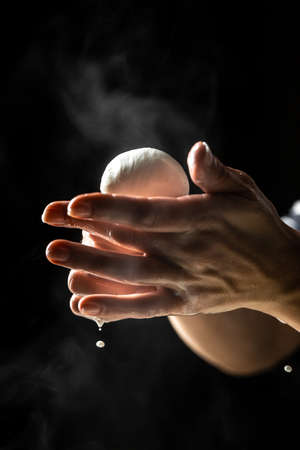 Production process of mozzarella cheese. woman working in a small family creamery is processing the final steps of making a cheese. Traditional Italian mozzarella.の写真素材
