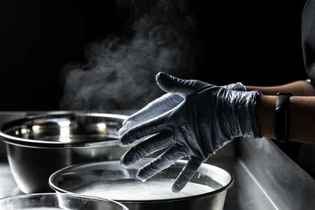 A woman working in a small family creamery is processing the final steps of making a cheese. Italian...