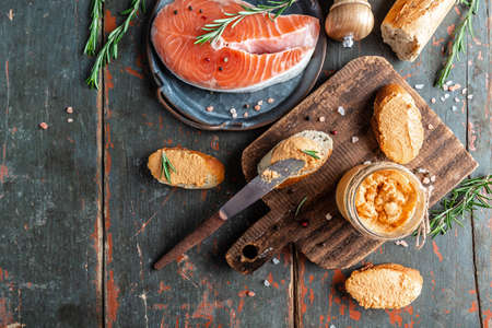 Smoked salmon and soft cheese spread, mousse, pate in a jar on toast wooden background. banner, catering menu recipe place for text, top view.の写真素材