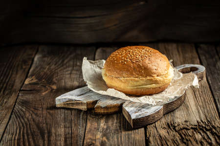 homemade sesame buns on a wooden board for made tasty hamburger. banner, menu, recipe, place for...