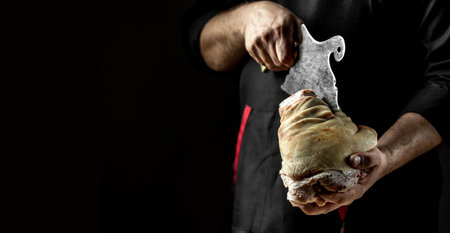 Close up of a chef hands preparing pork knuckle. Cook preparing delicious pork knuckle with the addition of beer. The concept of Bavarian cooking recipeの写真素材