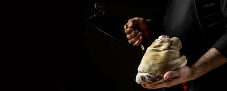Close up of a chef hands preparing pork knuckle. Cook preparing delicious pork knuckle with the addition of beer. The concept of Bavarian cooking recipe.の写真素材