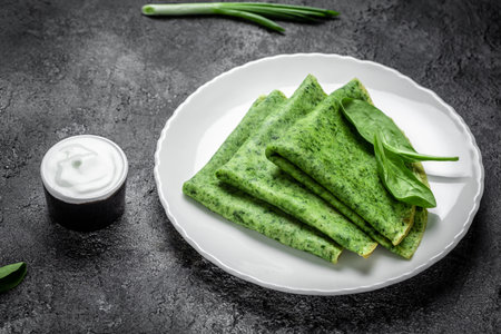 Spinach green pancakes crepes on white plate. Delicious healthy breakfast. vegetarian food, top view.の写真素材