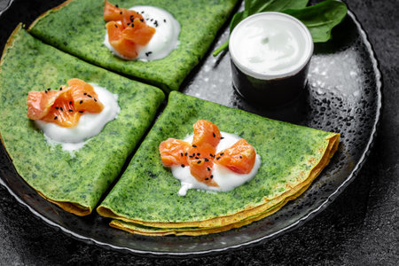 Green vegan crepes with spinach, smoked salmon and yogurt sauce, Healthy breakfast, vegetarian food,...