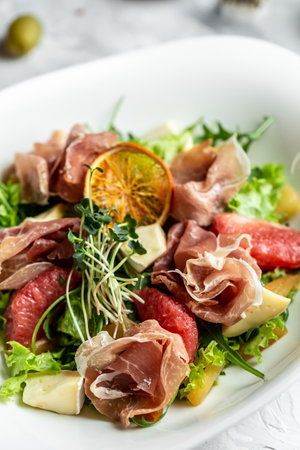 Salad with Prosciutto, ham and grapefruit jamon, salad mix, grapefruit, cherry tomatoes, parmesan cheese. vertical image, place for text.の写真素材