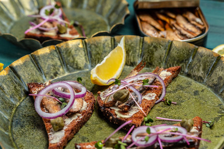 Sandwich smorrebrod with sprats, tomatoes and cream cheese on an old metal tray. Food recipe background. close up.の写真素材