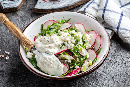 Rustic salad with radish, arugula, cottage cheese, and sour cream. Healthy vegetarian food.の写真素材
